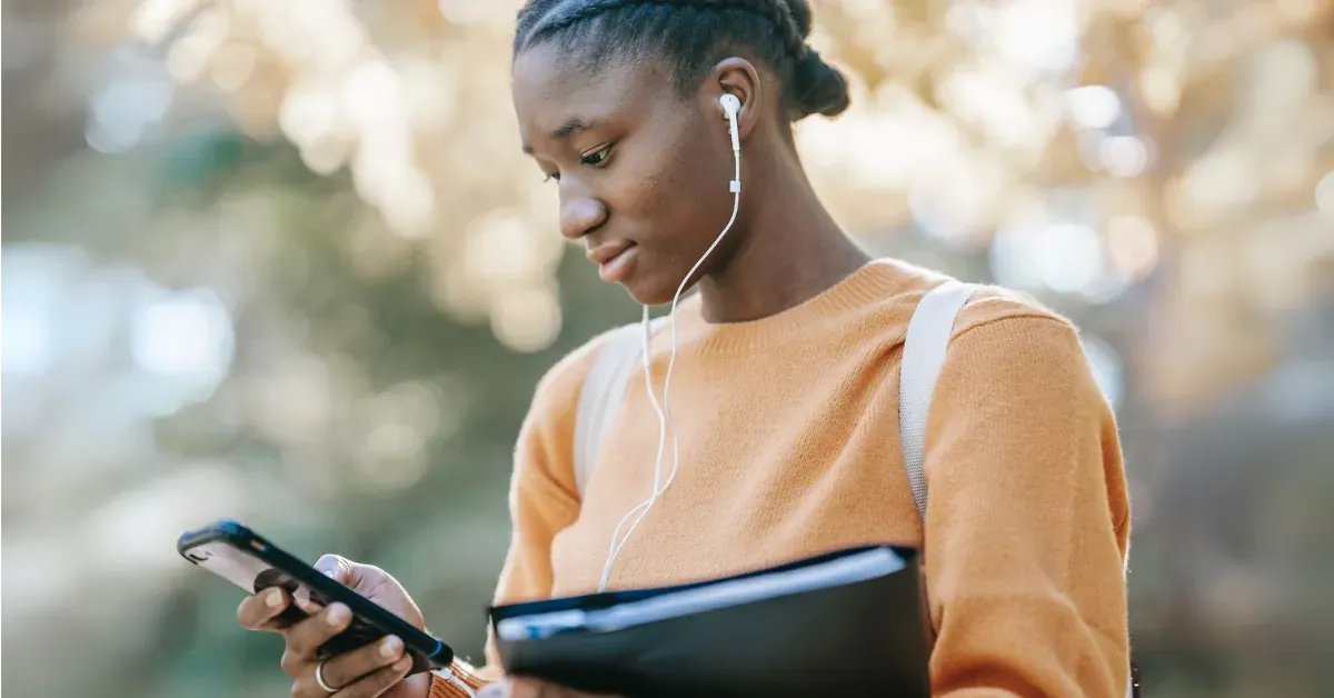 Young woman listening to audio content on her smartphone.