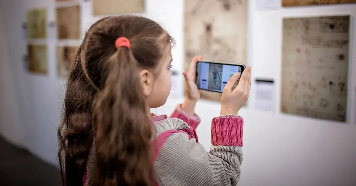 A young girl using the AR feature of a self-guided tour app in a museum.